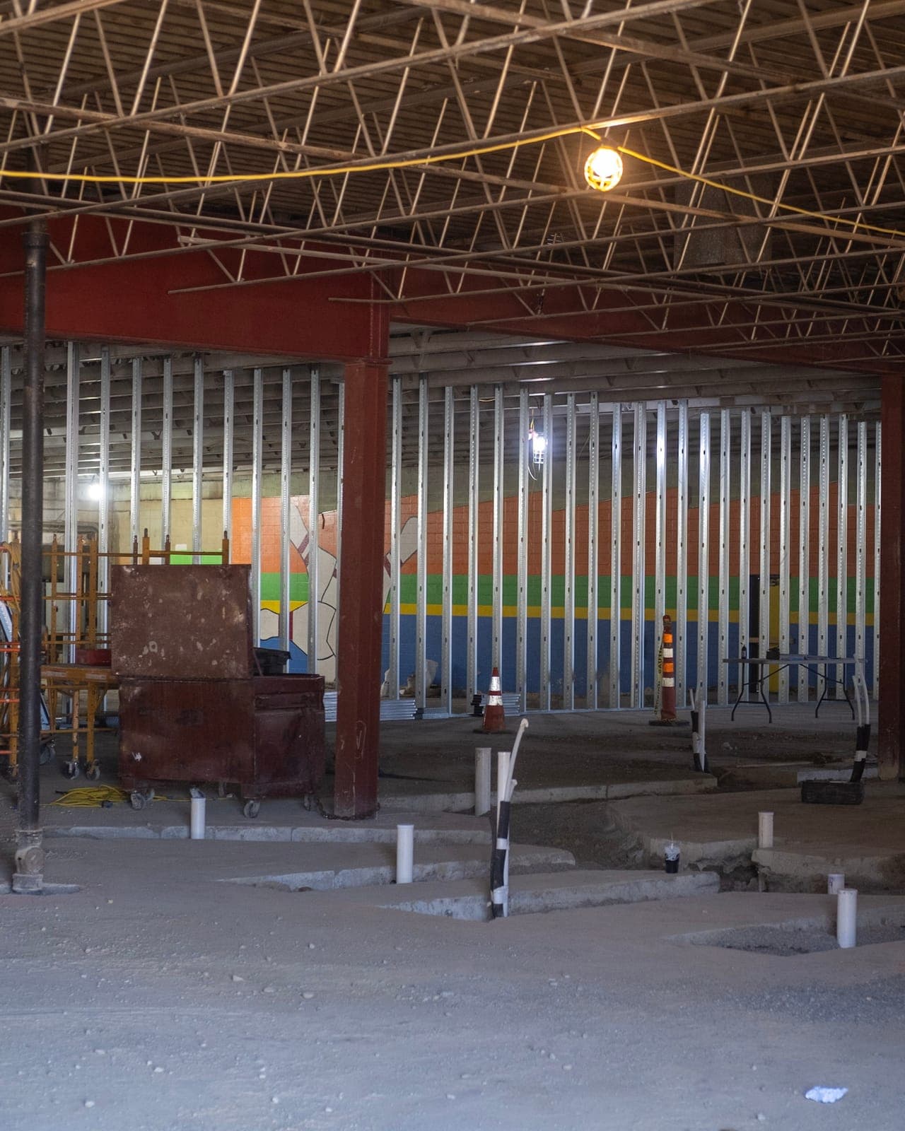 New framing in front of the old bowling alley's rainbow-striped wall