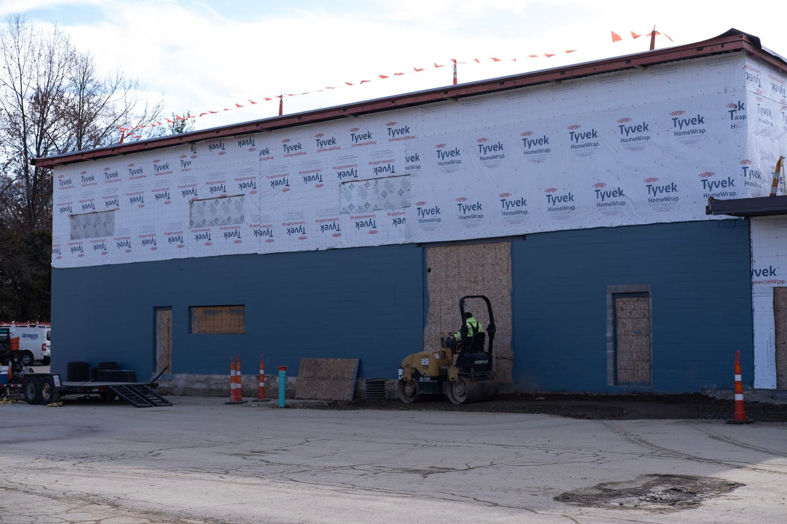 New exterior walls wrapped in Tyvek above the blue block building