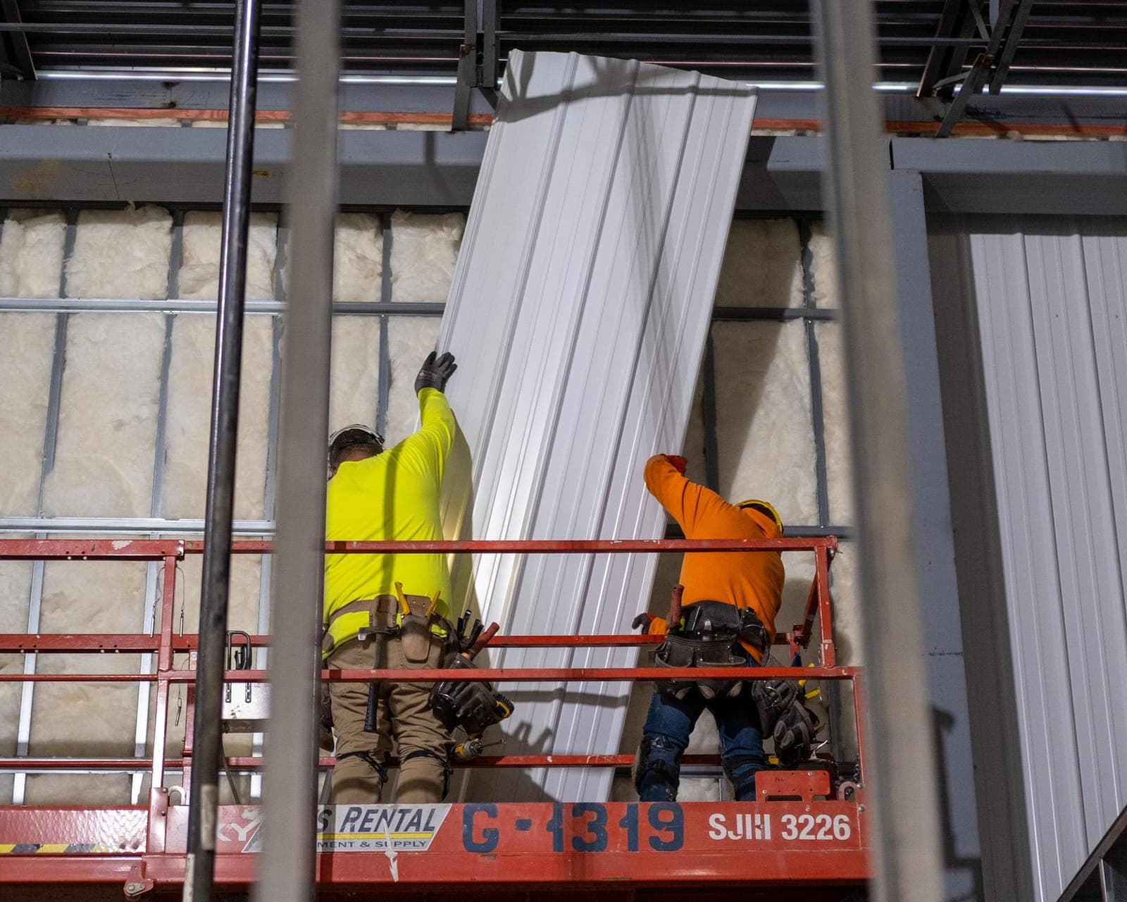 Crew members on a lift working on the brewery walls