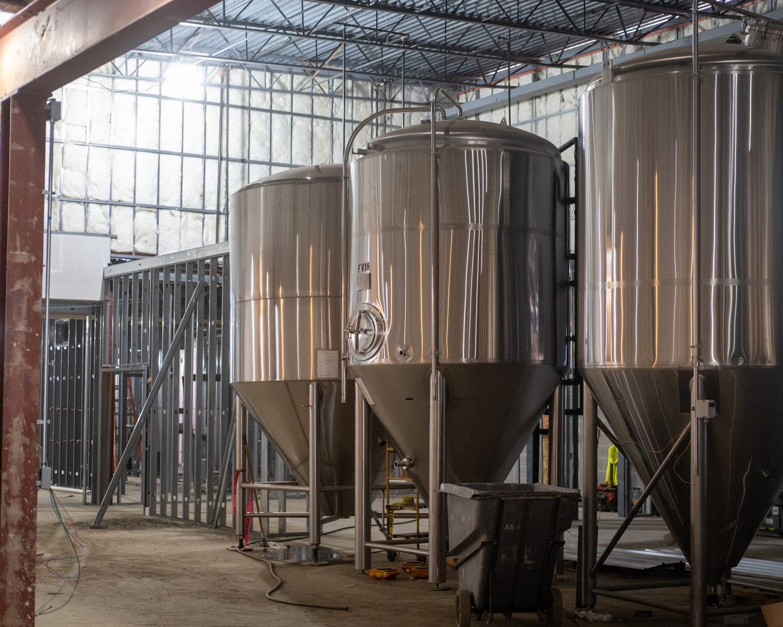 Fermentation tanks in the brewery space awaiting install