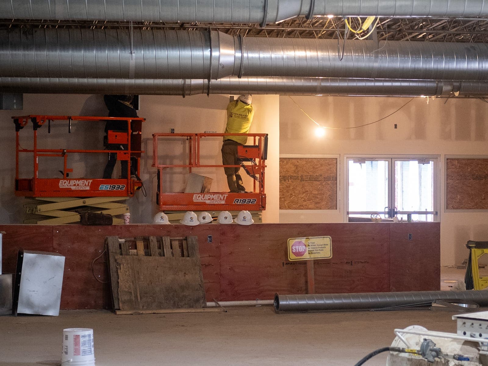 Workers on a lift above the future bar