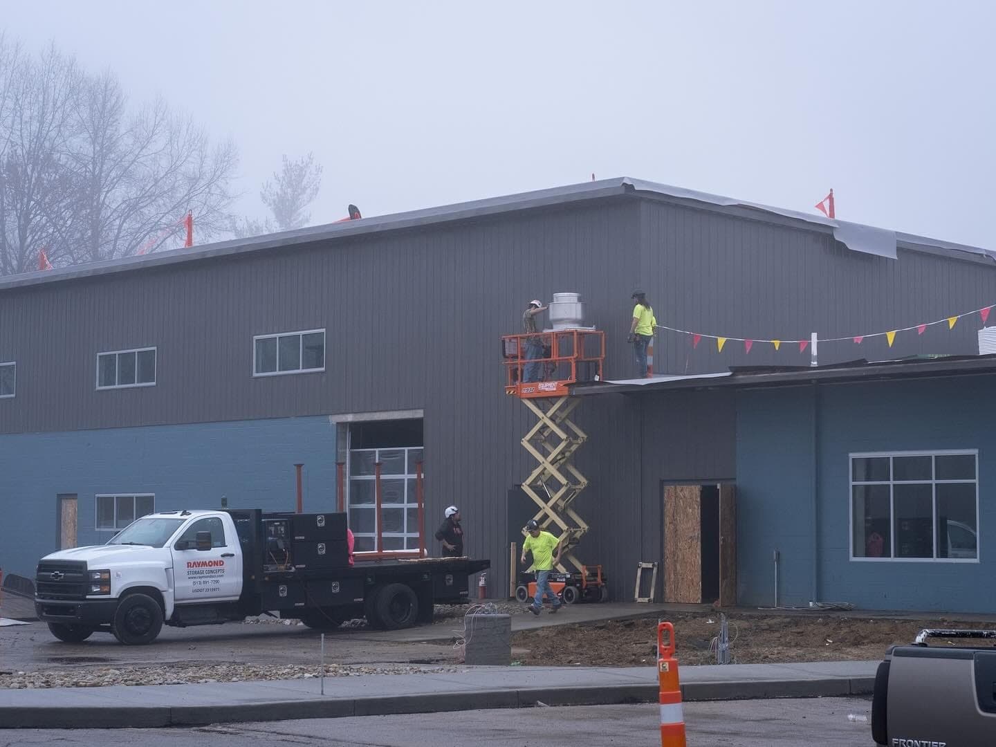 The Brentwood exterior with a scissor lift and work truck