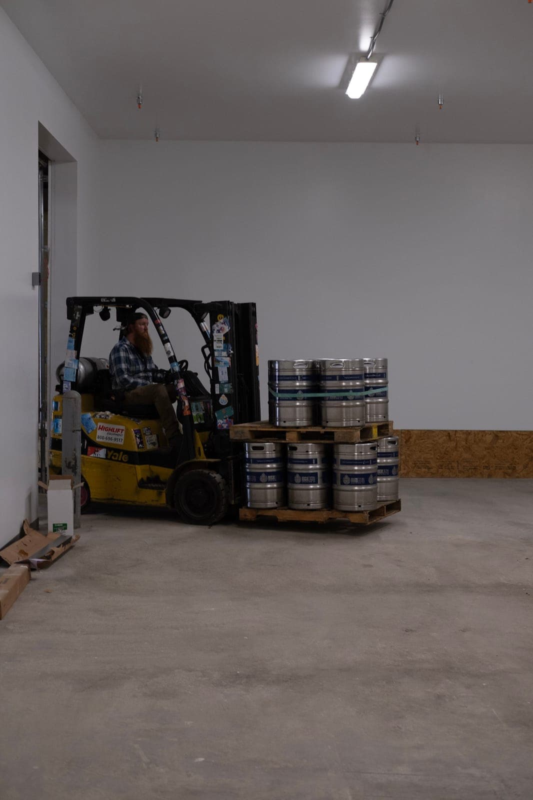 A forklift moving a pallet of kegs into the new brewery